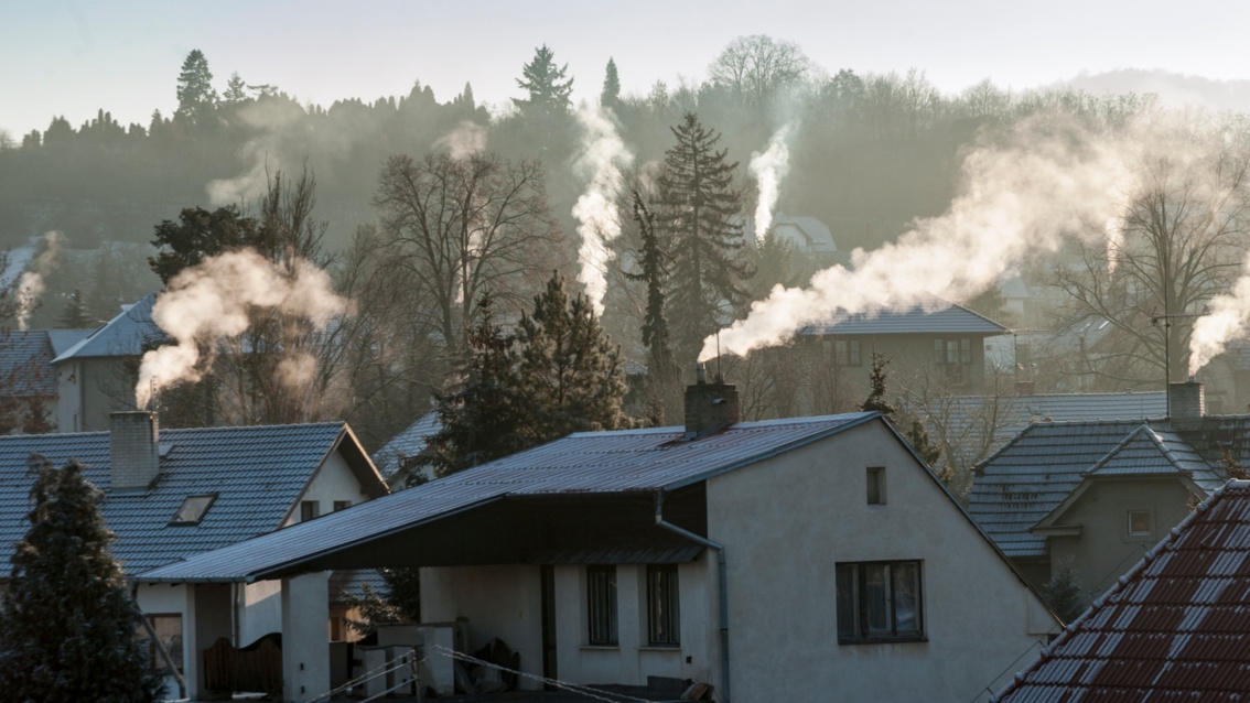 Ansicht eines Dorfes im Winter mit qualmenden Schornsteinen