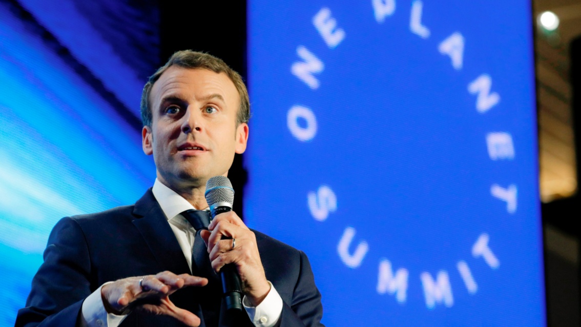 Präsident Emanuel Macron spricht, im Hintergrund das Logo One Planet Summit.