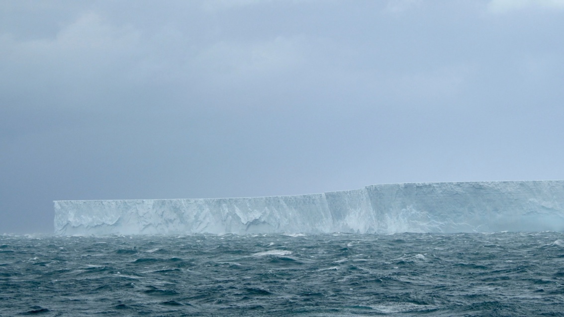 Ein flacher Eisberg in düsterer, kalter Lichstimmung 
