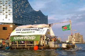 Floß mit Protestbanner vor dem Hamburger Elphilharmonie