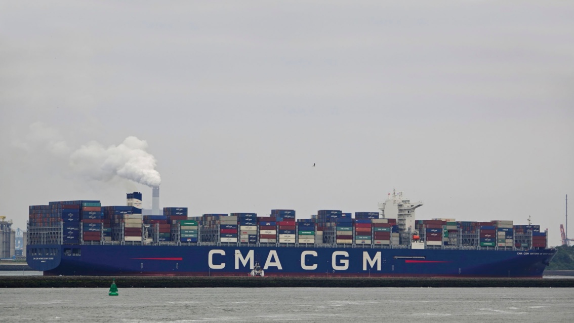 Eines ewig langes beladenes Containerschiffe mit der Aufschrift CMA CGM, liegt im Hafen.