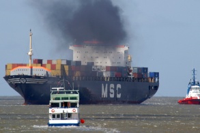 Containerschiff mit schwarzem Dieselqualm
