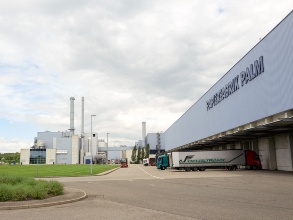 Ansicht einer Biogasanlage, auf einem danebestehenden Gebäude ist der Schriftzug «Papierfabrik Palm» zu erkennen.