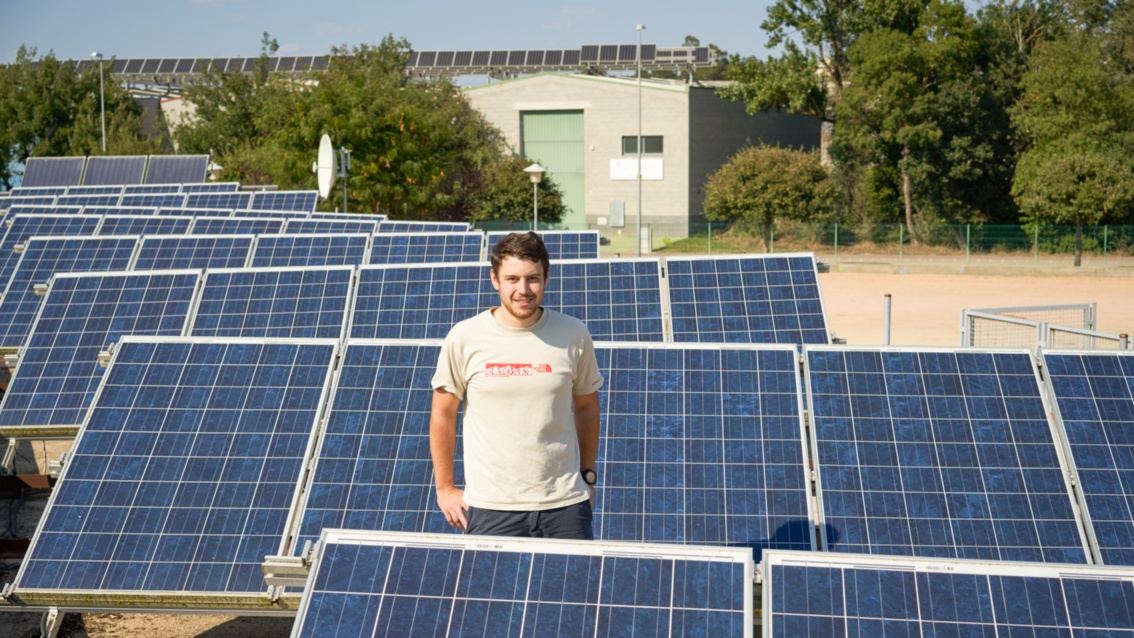 Eib Mann im T-Shirt im Grünen inmitten von Solarmodulen