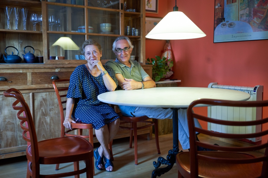 Ein älteres Ehepaar am Tisch unter einen großen hellen Lampe.