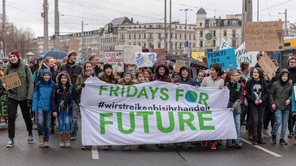 Ein Demo-Block mit sehr jungen Schülerinnen und Schülern hält ein großes Transparent mit der Aufschrift: Fridays for Future.