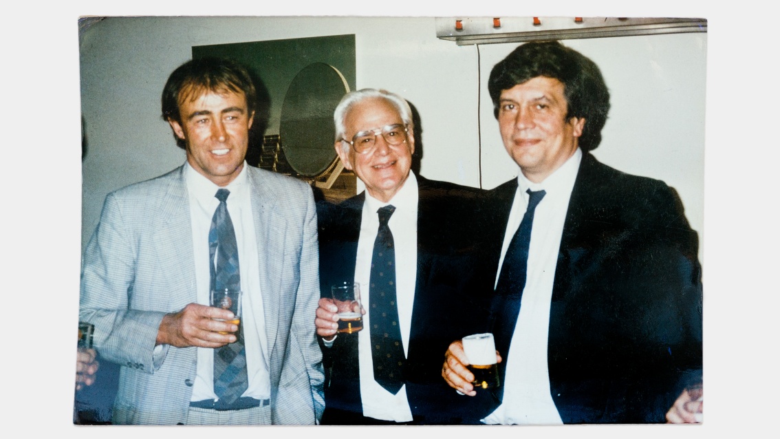 Drei Herren in Anzügen und jeweils mit einem Bierglas in der Hand, stehen nebeneinander.