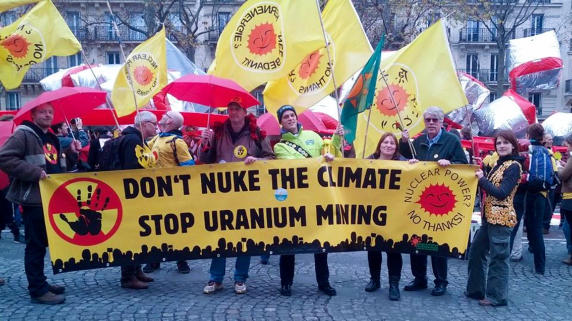 Auf einer Anti-Atom-Demo steht eine Reihe von Leuten. Sie halten ein großes Transparent, auf dem steht: «Don't nuke the climate. Stop uranium mining».