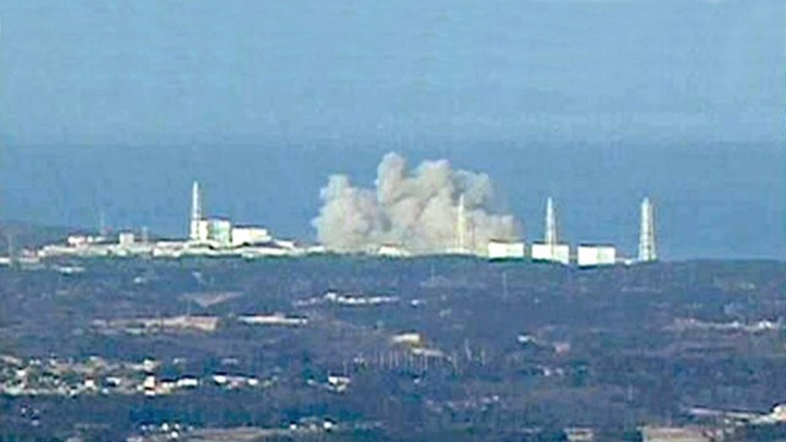 Ein sehr unscharfes pixeliges Bild zeigt, vom Meer aus fotografiert, eine gewaltige Explosionswolke in einem Teil des Kraftwerkes.