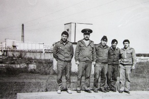Grupppenbild von Arbeitern mit dem Reaktor im Hintergrund