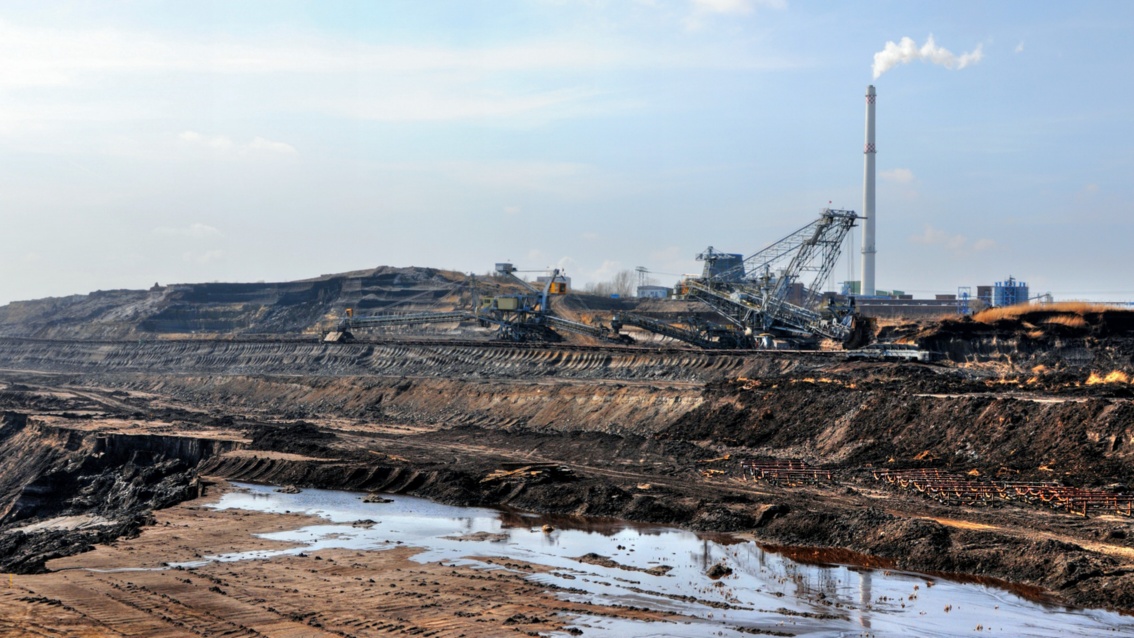 Eine zerstörte Landschaft mit Kohlebaggern und einem Kraftwerk