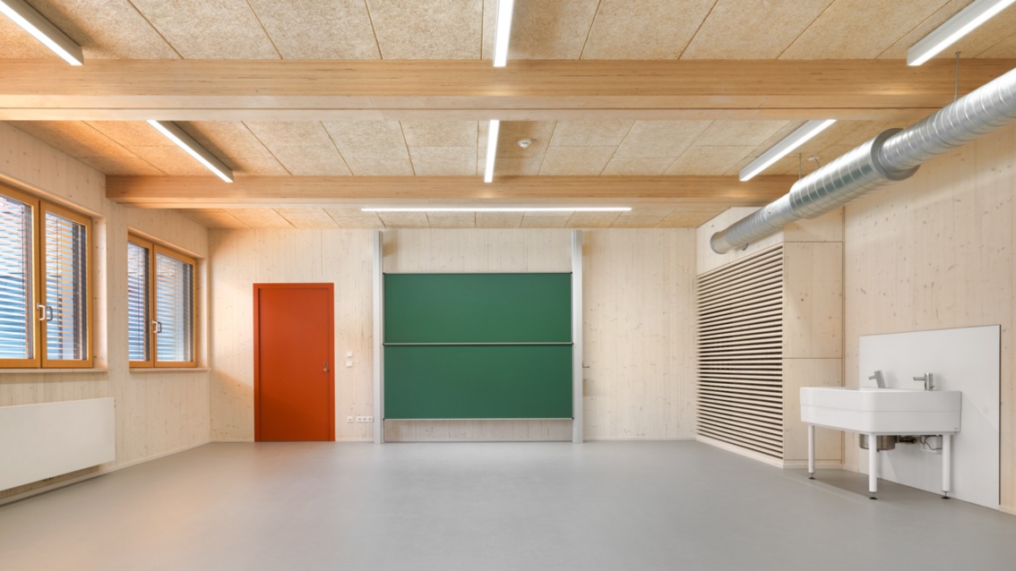 Ein lichtdurchfluteter Schulraum mit viel sichtbarem Holz