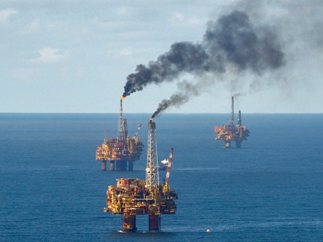 Luftaufnahme mehrerer Ölförderplattformen im offenen Meer.