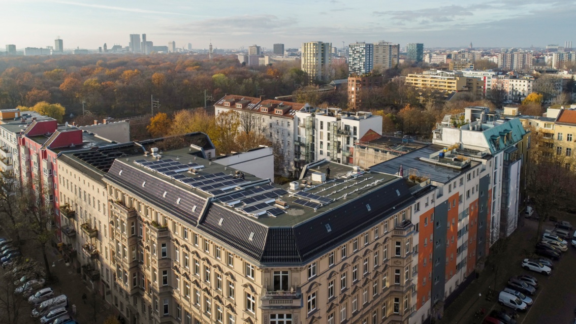 Luftaufnahme eines Berliner Gründerzeit-Hauses, auf dem eine große Dachfäche mit PV-Modulen belegt ist.