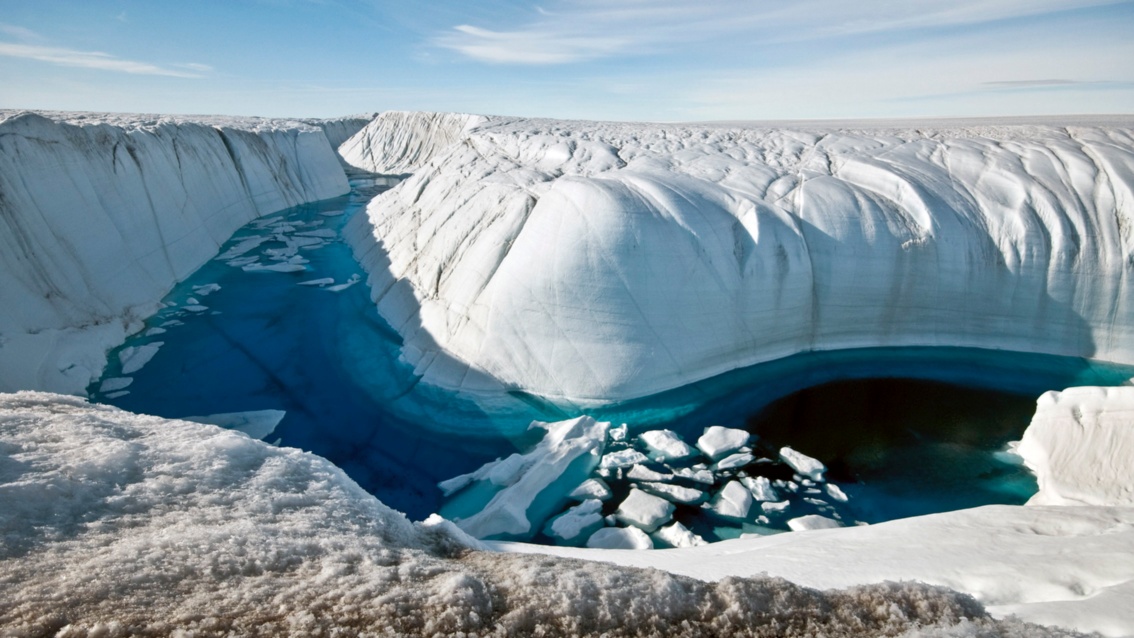 Ein Fluss mit tiefblau-grünem Wasser mäandert durch weiße bucklige rundgewaschene Eisfelsen.