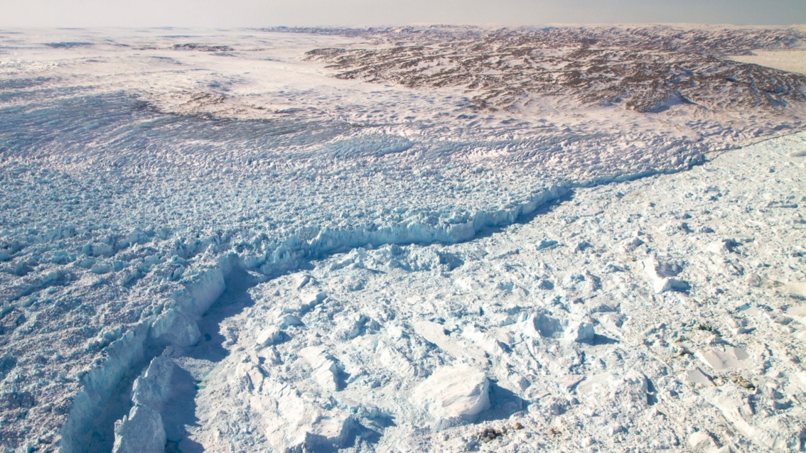 Eine riesige Fläche zerklüfteten Eises ist in einer geschwundenen Linie getrennt von einer auch gebrochenen dichten Eisfläche.