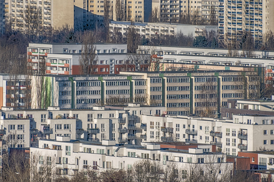 Ansicht einer großstädtischen Siedlung mit in die Tiefe des Bildes gestaffelten Wohnblocks.