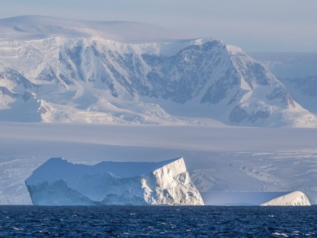Ein Eisberg treibt vor der antarktischen Küste im Meer.