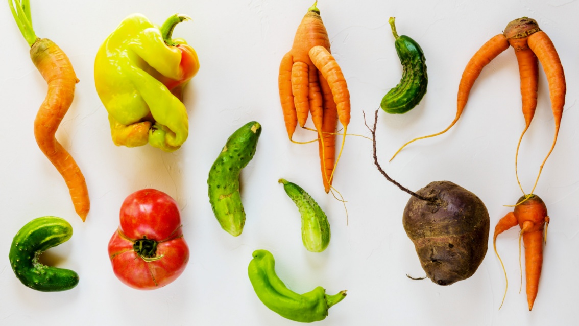 Gemüse in ungewohnter Form: krumme Gurken, mehrbeinige Karotten und eine dellige Paprikaschote. 