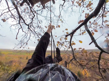 Blick mit einer Helmkamera von Bäumen auf Tagebau, die filmende Person hält sich an einem Seil fest.