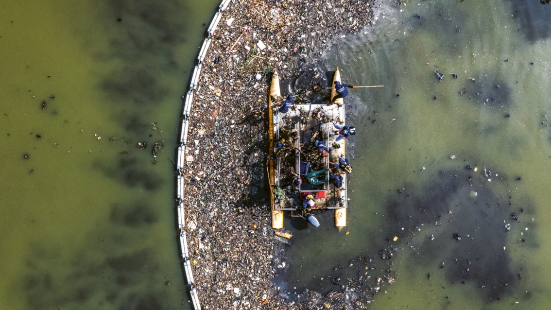 Von oben: Hinter einer Barriere treibt ein Katamaran inmitten von Kunststoffmüll – Arbeiter fischen ihn aus dem Wasser. 