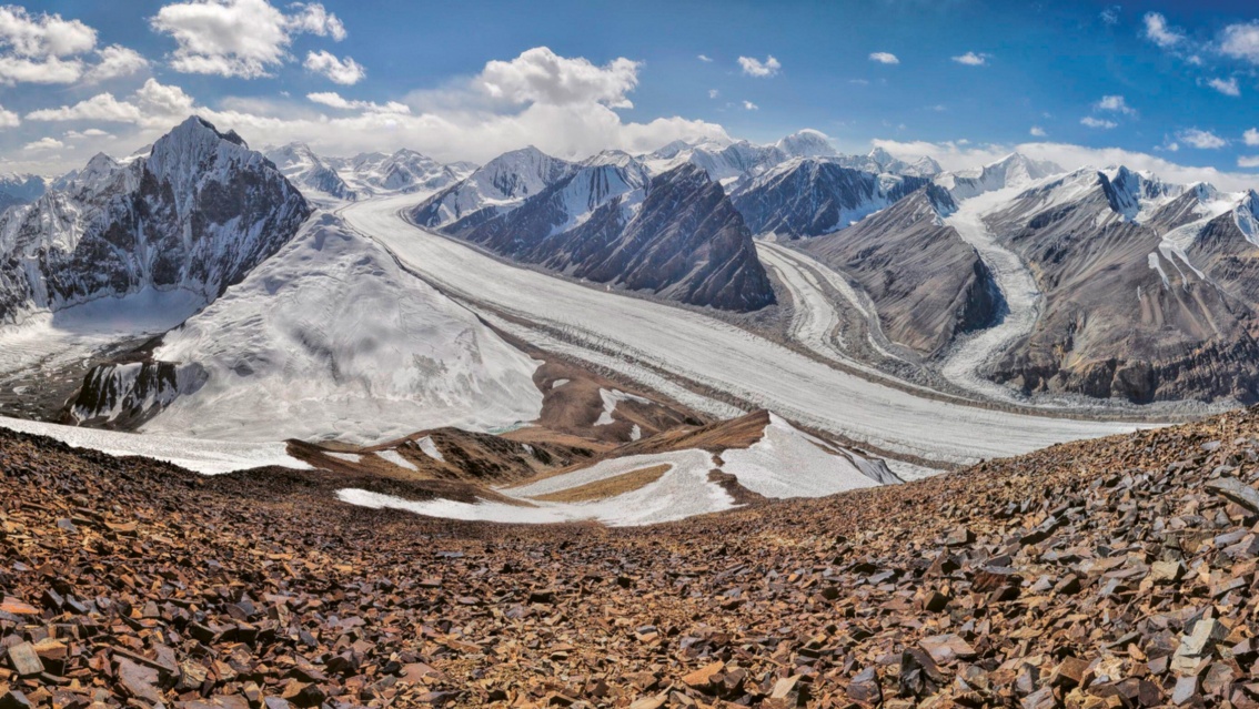 Ein weites Hochgebirgspanorama: im Vordergrund ziehen sich Gletscher straßengleich durch Täler.