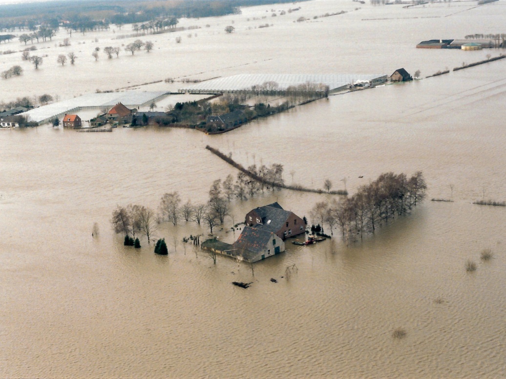 Historische Luftaufnahme einer vollkommen überschwemmten Flusslandschaft.