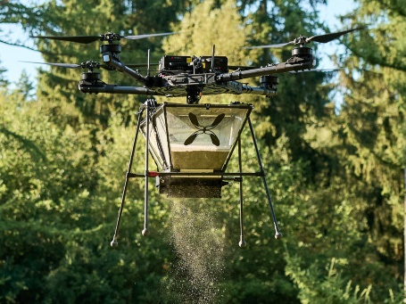 Eine Drohn verstreut Pellets in einer Waldlichtung