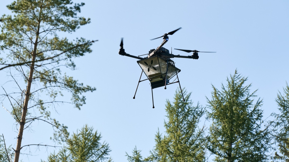 Die ungewöhnliche Drohne schwebt mit ihren vier Rotoren zwischen den Baumwipfeln. 