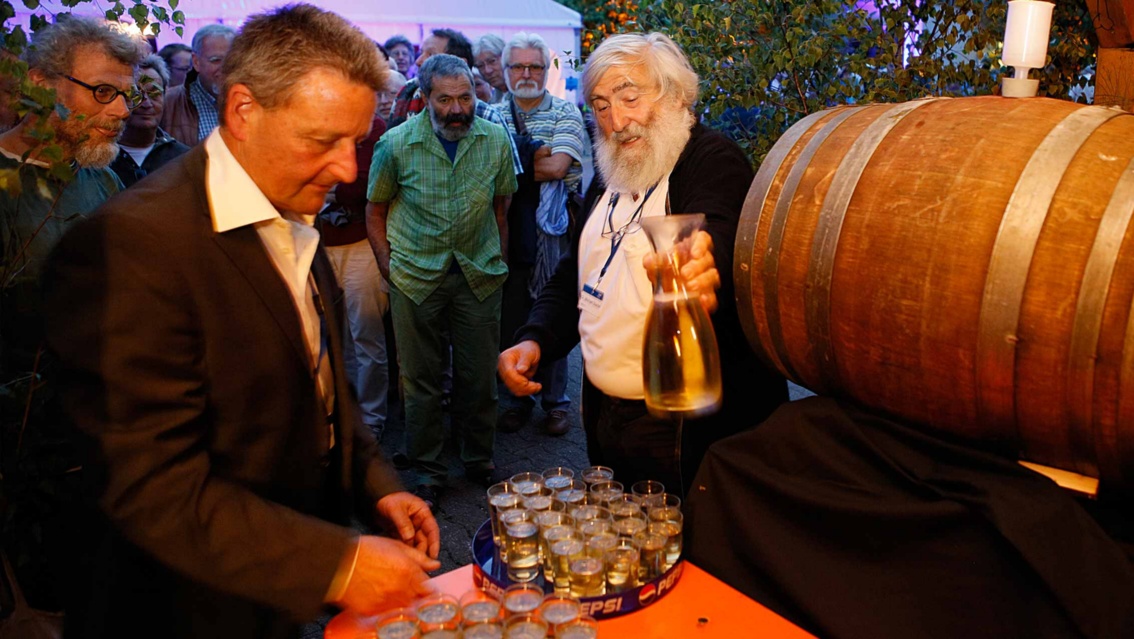 Rolf Wetzel schenkt den frischgezapften Gutedel in Weingläser.