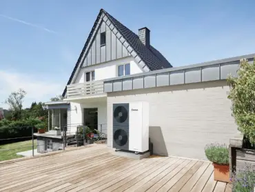 Modernes Gebäude mit Garten, großer Holzterrasse und Wärmepumpe