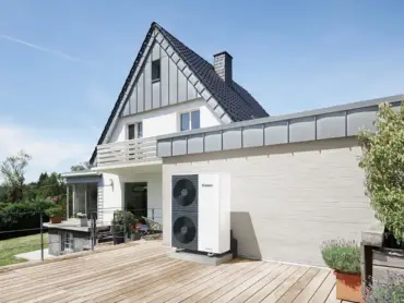 Modernes Gebäude mit Garten, großer Holzterrasse und Wärmepumpe