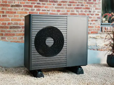 Wärmepumpe vor einer Backsteinwand