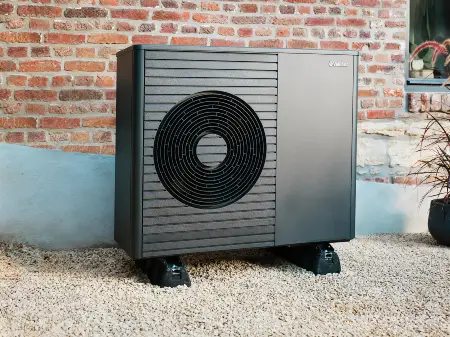 Ein Einfamilienhaus, an dem eine Wärmepumpe angebracht ist