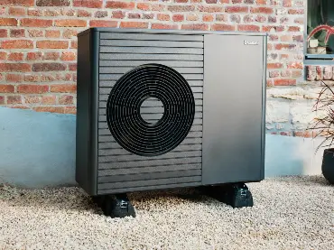 Wärmepumpe vor einer Backsteinwand