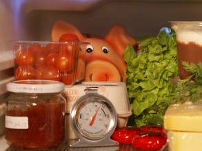 Sparschwein im Gemüsefach eines Kühlschranks