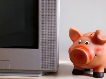 Sparschwein neben Fernsehgerät