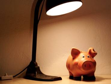 Sparschwein unter Schreibtischlampe