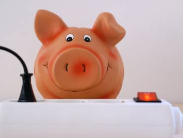 Sparschwein vor Steckerleiste