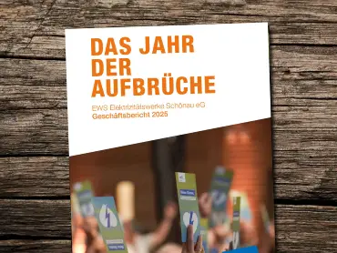 Auf einer Holzfläche liegt ein Geschäftsbericht