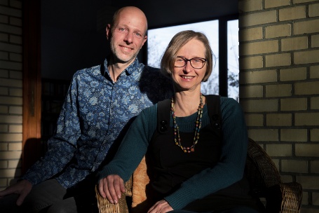 Die greenap-Gründer Georg Amshoff und Sabine te Heesen stehen im Freien vor einer hellen Ziegelwand.