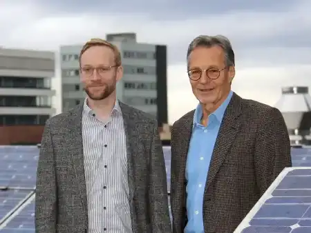 Zwei Männer zwischen Solarmodulenauf dem Hotel Victoria in Freiburg
