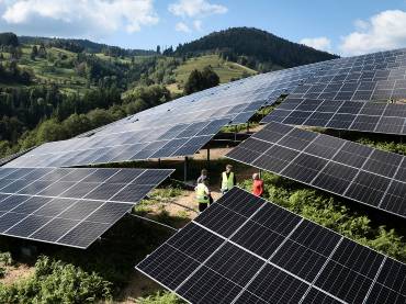 Der Solarpark Fröhnd aus Vogelperspektive, zwischen den Modulen sind drei Menschen in Warnwesten zu erkennen