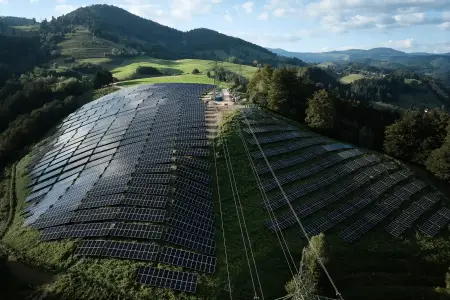 Eine große PV-Anlage erstreckt sich auf den Anhöhen des Schwarzwalds einen steilen Bergrücken herab.