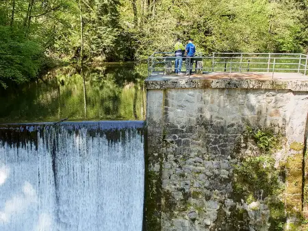 Zwei Personen stehen auf der Staumauer des Wasserkraftwerks Köhlgartenwiese.