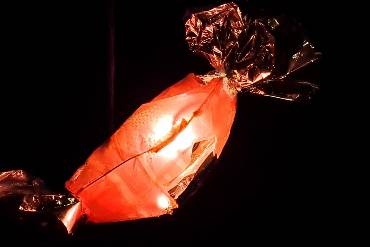 Eine erleuchtete Laterne, die aussieht wie ein Bonbon, vor dunklem Nachthimmel