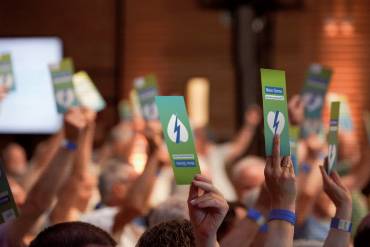 Mehrere Hände halten Stimmkarten hoch