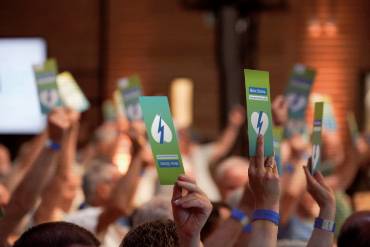 Zahlreiche Hände halten Stimmkarten hoch