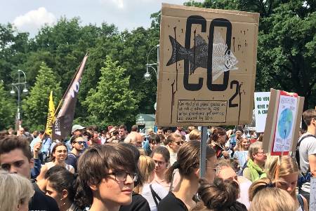 Teilnehmende an einem Klimastreik mit großem Demonstrationsschild