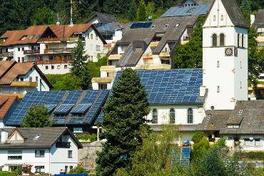Ansicht des Ortes Schönau, im Zentrum die Kirche mit dem komplett mit PV-Modulen bestückten Dach.